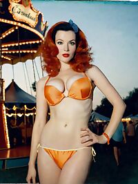 A sultry 1950s siren in an orange bikini captivating the twilight air at a vintage carnival