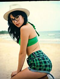 Woman stands on the beach under the sunset's warm light as she gazes out at the waves