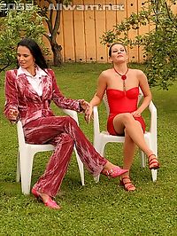 Two hot lesbian babes playing with a garden hose outside