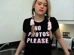 Syrup on her tits : A young, blonde girl is standing in the kitchen corner. The cameraman asks her to lift her T-shirt so he can film her large breasts. The girl then removes her shirt and pours syrup over her tits, making it run down her body and then washing it off.